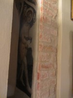 Particolare di un San Sebastiano dipinto su una mezza colonna al piano terra